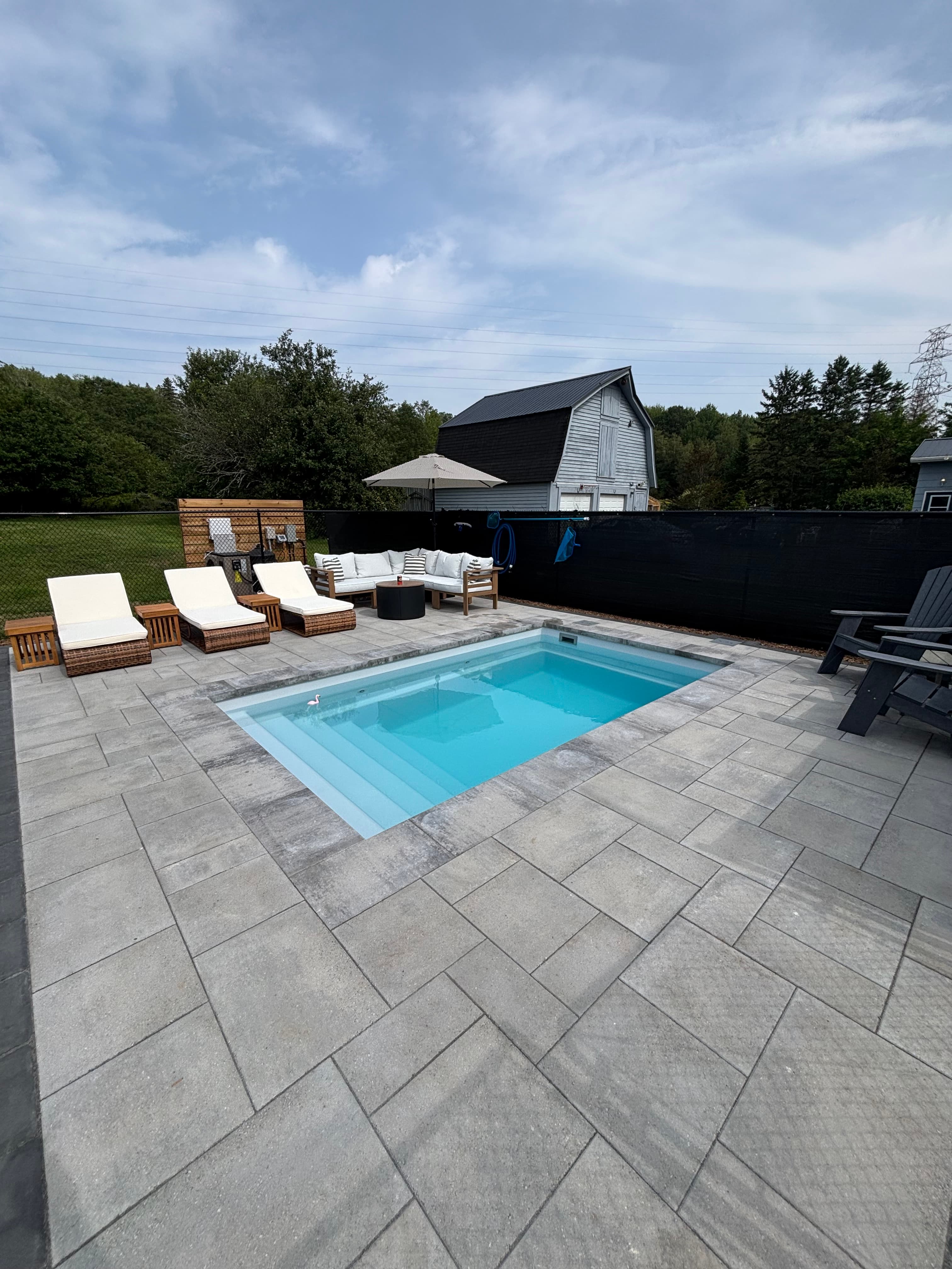 Plunge pool with adirondack chairs and hammock in backyard