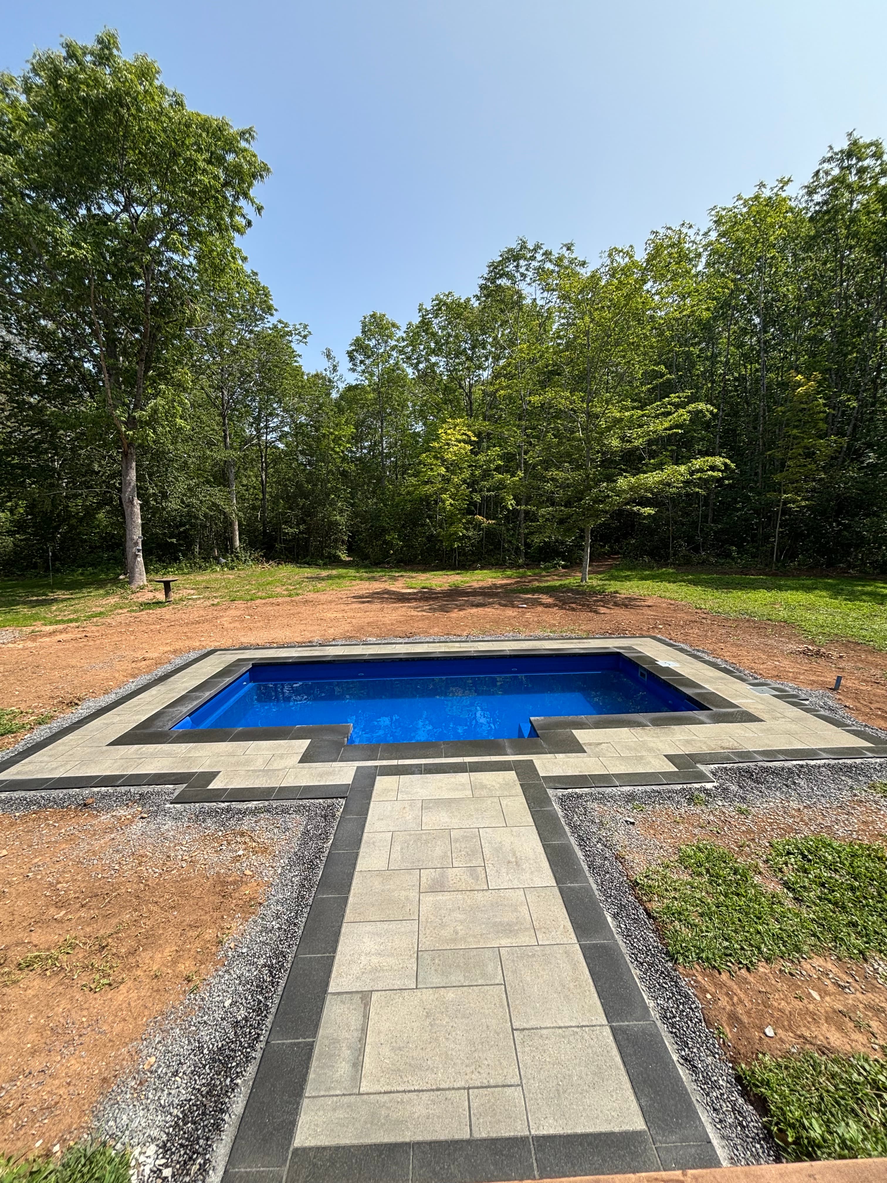 Plunge pool with lounge chairs and barn in the background