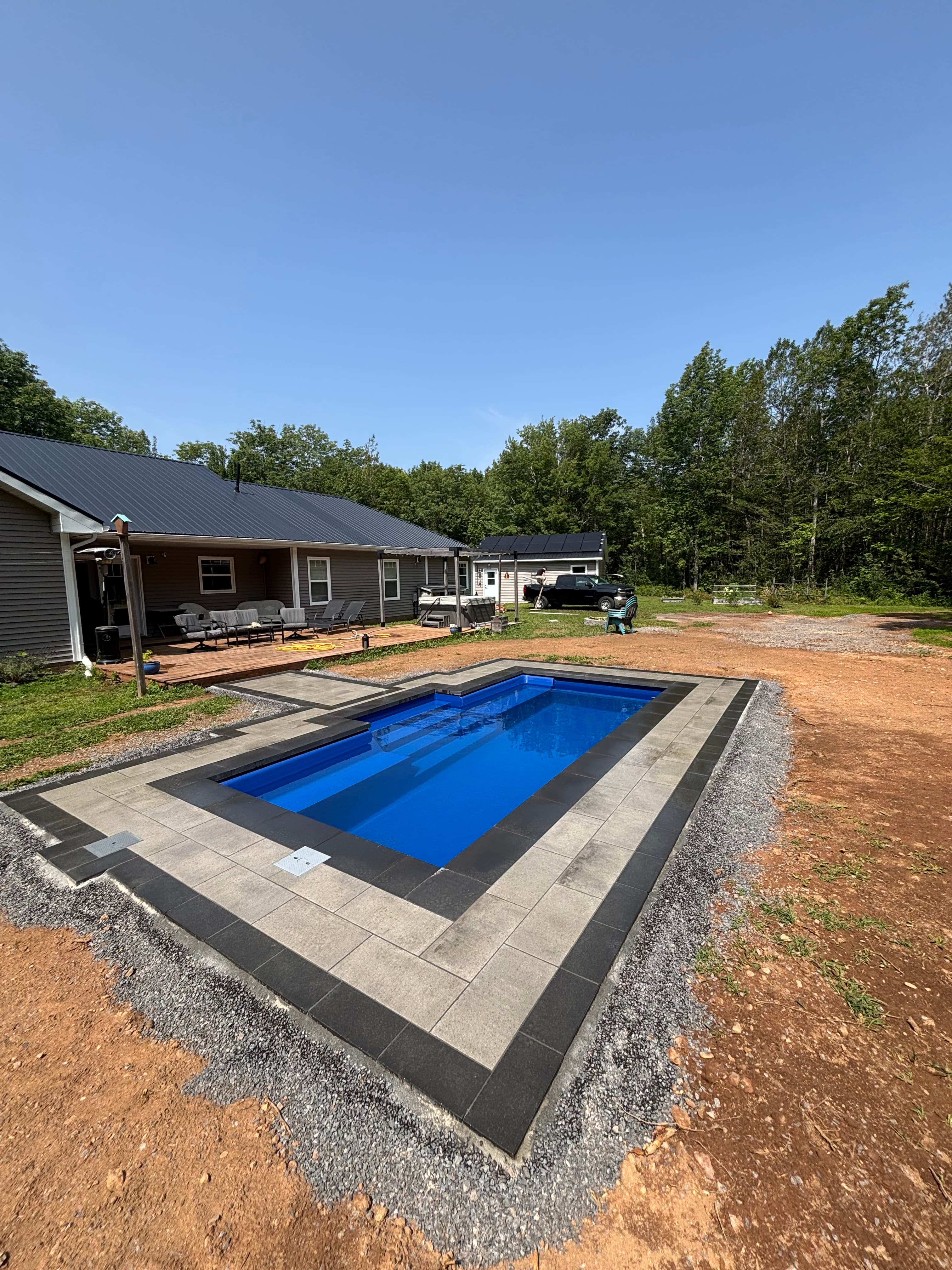 Plunge pool with paver border in a wooded Nova Scotia yard