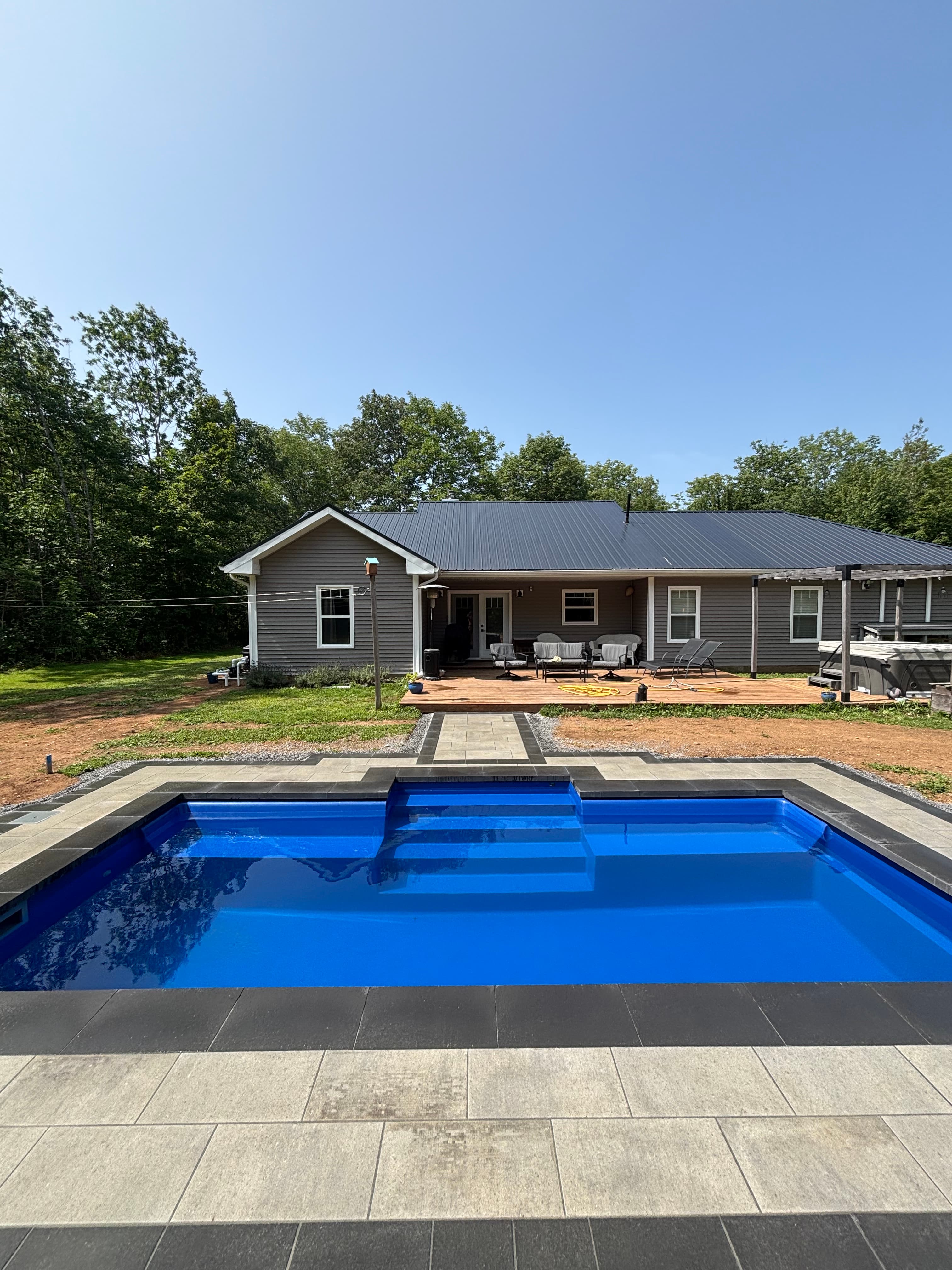 Plunge pool with paver walkway in a forest clearing