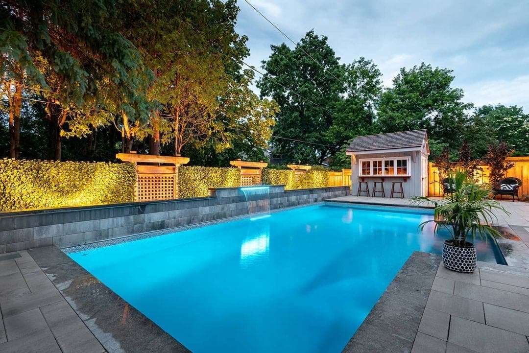 Twilight pool installation with waterfall and outdoor bar